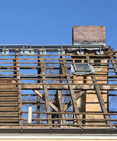 Toiture en cours de dépose avant une rénovation, avec la charpente apparente