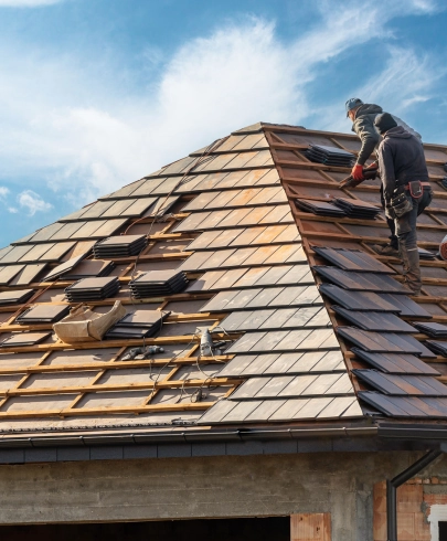 Ouvrier intervenant sur un toit lors de la dépose de tuiles